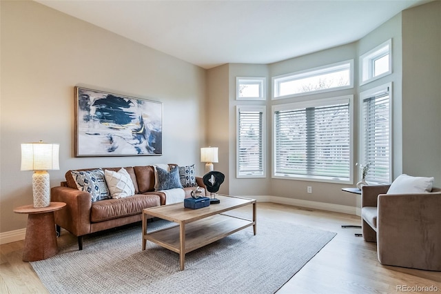 living area with plenty of natural light, light wood finished floors, and baseboards