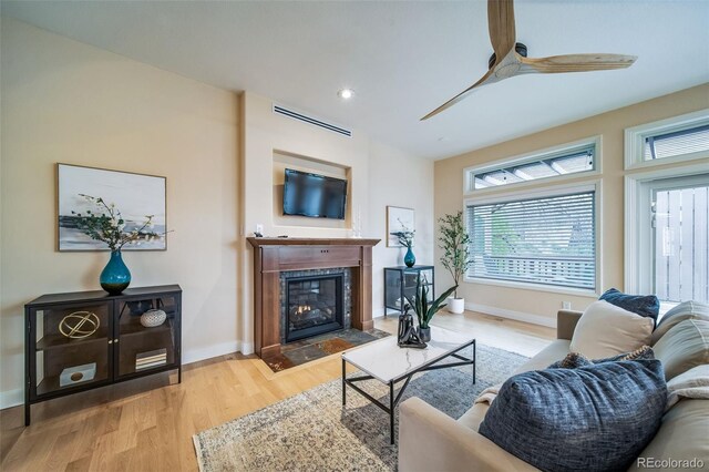 living room featuring ceiling fan, plenty of natural light, wood finished floors, a fireplace with flush hearth, and recessed lighting