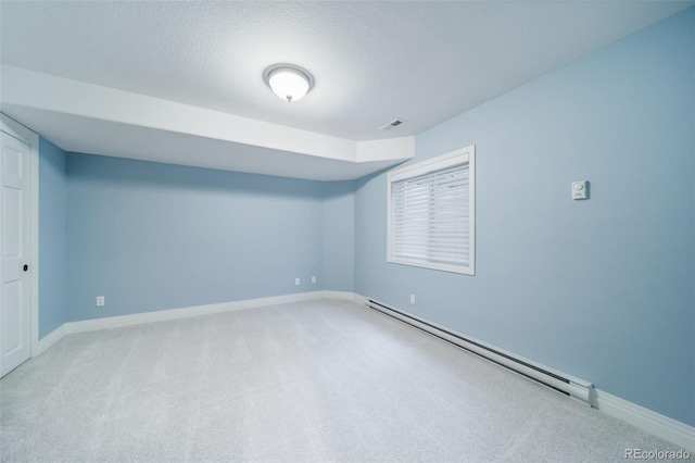unfurnished room featuring baseboard heating, carpet, baseboards, and a textured ceiling