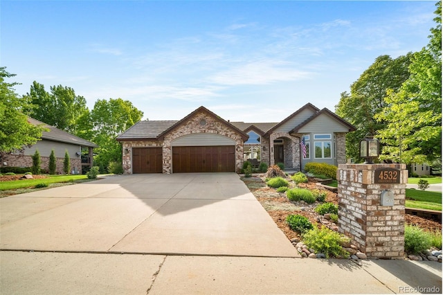 4532 Christensen Cir, Littleton, CO 80123 - view of front facade featuring an attached garage, concrete driveway, and stone siding