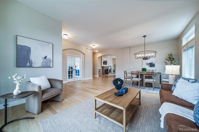 4532 Christensen Cir, Littleton, CO 80123 - living area featuring arched walkways, wood finished floors, a chandelier, and baseboards