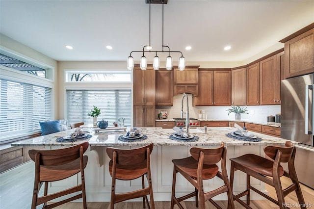 4532 Christensen Cir, Littleton, CO 80123 - kitchen featuring freestanding refrigerator, light wood-type flooring, decorative backsplash, light stone counters, and recessed lighting