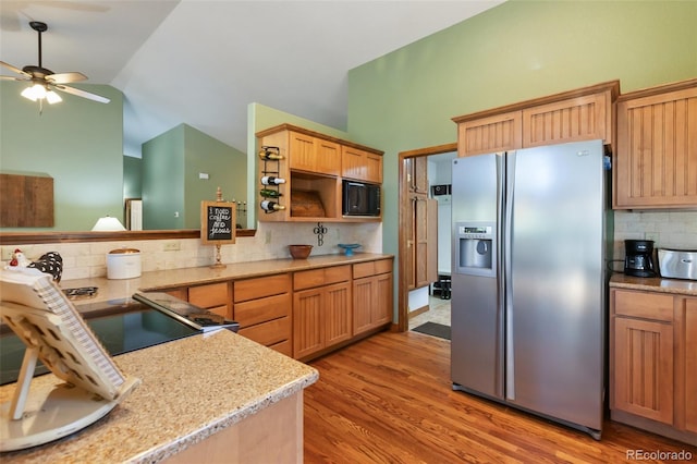 kitchen featuring stainless steel refrigerator with ice dispenser, tasteful backsplash, a ceiling fan, light wood-style flooring, and high vaulted ceiling