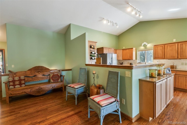 kitchen with rail lighting, white refrigerator with ice dispenser, wood finished floors, decorative backsplash, and high vaulted ceiling