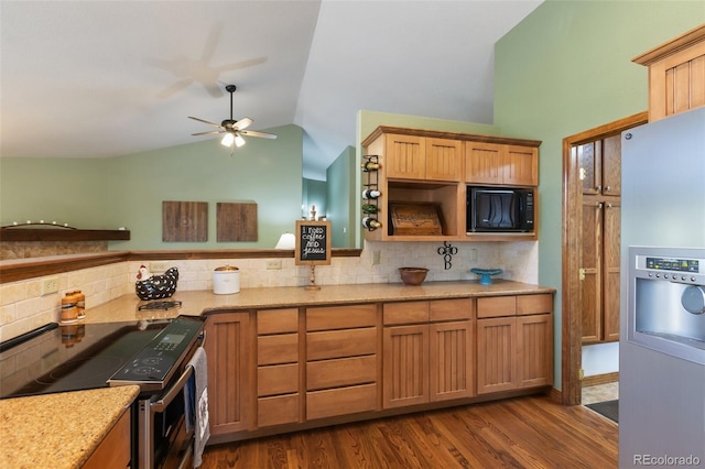 kitchen featuring stainless steel appliances, lofted ceiling, tasteful backsplash, a ceiling fan, and light stone countertops
