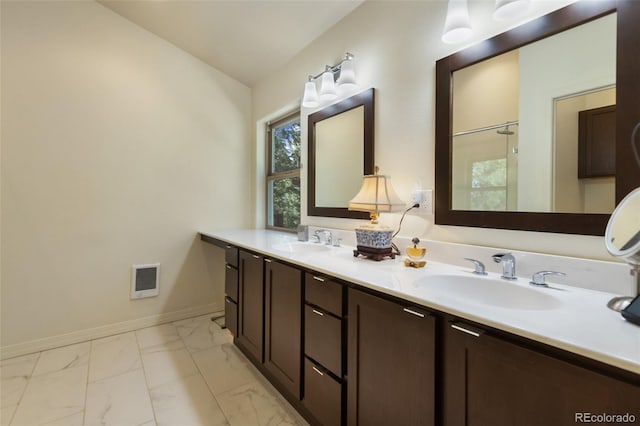bathroom featuring marble look tile flooring, double vanity, and a shower