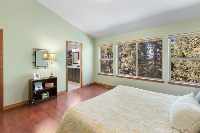 bedroom with wood-type flooring, lofted ceiling, and ensuite bath