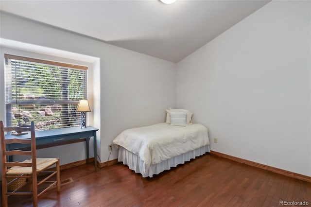 bedroom featuring dark wood finished floors and lofted ceiling
