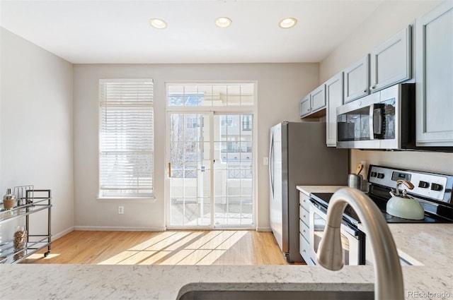 kitchen with plenty of natural light, recessed lighting, light wood finished floors, and appliances with stainless steel finishes