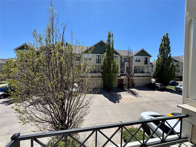 view of front facade with driveway, a residential view, a garage, and fence