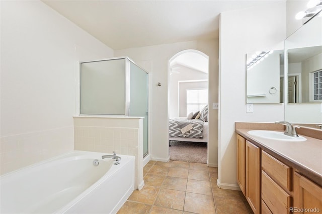 bathroom with vanity, baseboards, ensuite bathroom, a bath, and a stall shower