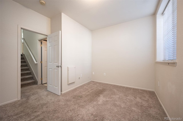 unfurnished bedroom featuring carpet floors, baseboards, and multiple windows