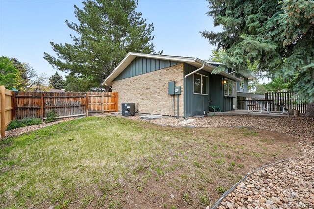 2495 S Lansing Way, Aurora, CO 80014 - rear view of property featuring central air condition unit, board and batten siding, brick siding, and a patio
