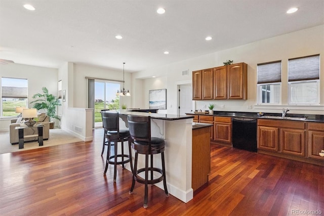 5605 Killen Ave, Castle Rock, CO 80104 - kitchen with dishwasher, a kitchen breakfast bar, dark countertops, brown cabinets, and recessed lighting