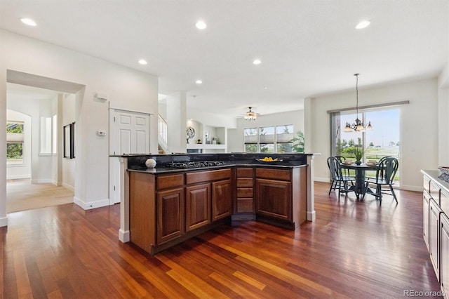 5605 Killen Ave, Castle Rock, CO 80104 - kitchen featuring dark wood-style flooring, recessed lighting, dark countertops, a kitchen island, and a chandelier