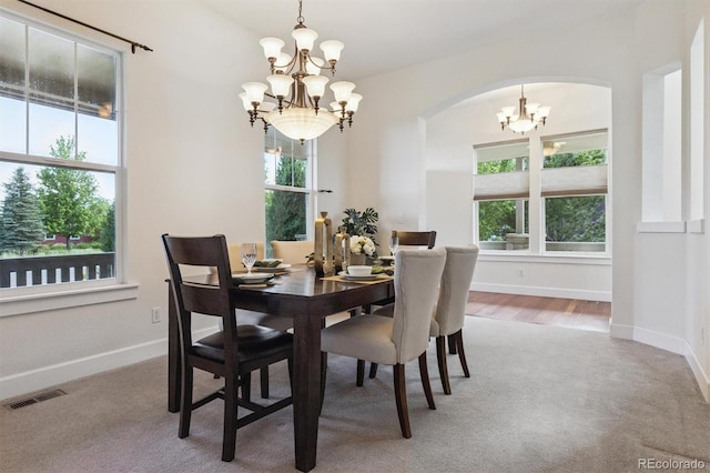 5605 Killen Ave, Castle Rock, CO 80104 - carpeted dining room featuring a chandelier, arched walkways, and healthy amount of natural light