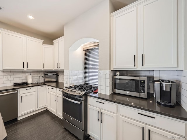 kitchen with white cabinetry, stainless steel appliances, dark hardwood / wood-style floors, and tasteful backsplash