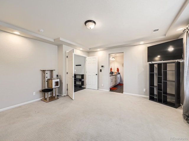 interior space with carpet and a tray ceiling