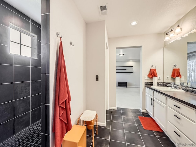 bathroom with vanity and a tile shower