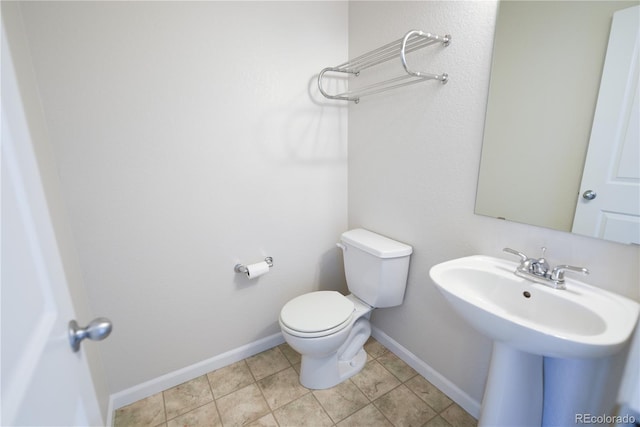 451 S Reed St, Lakewood, CO 80226 - half bathroom featuring toilet, baseboards, tile patterned flooring, and a sink