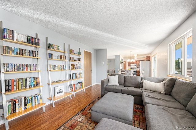 4844 E 110th Pl, Thornton, CO 80233 - living room featuring a textured ceiling, wood finished floors, and a chandelier