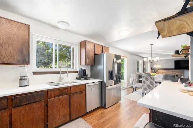 4844 E 110th Pl, Thornton, CO 80233 - kitchen featuring appliances with stainless steel finishes, light countertops, light wood-type flooring, pendant lighting, and a chandelier