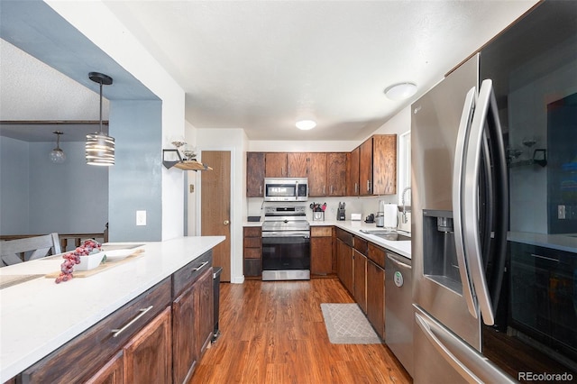 4844 E 110th Pl, Thornton, CO 80233 - kitchen with stainless steel appliances, wood finished floors, light countertops, and pendant lighting