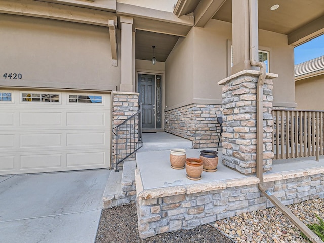 property entrance featuring a garage, stone siding, and stucco siding