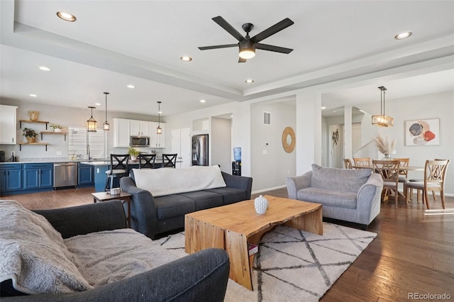 18079 E 108th Pl, Commerce City, CO 80022 - living area with baseboards, ceiling fan, recessed lighting, wood finished floors, and a tray ceiling