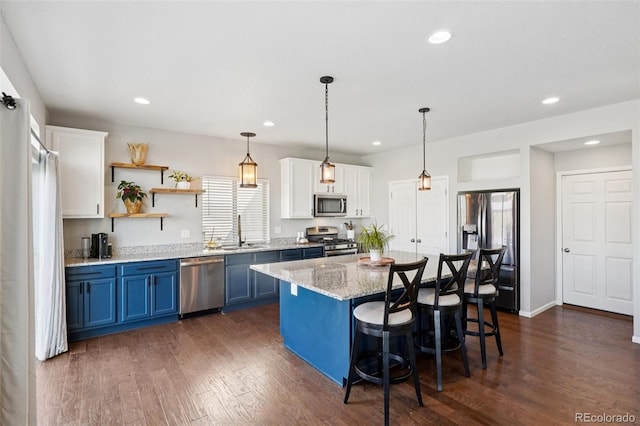 18079 E 108th Pl, Commerce City, CO 80022 - kitchen featuring stainless steel appliances, blue cabinets, a sink, a breakfast bar area, and white cabinets