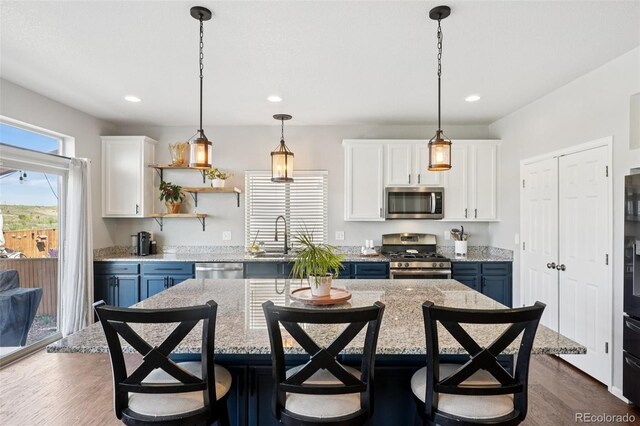 18079 E 108th Pl, Commerce City, CO 80022 - kitchen with appliances with stainless steel finishes, white cabinetry, a breakfast bar area, recessed lighting, and dark wood-style floors