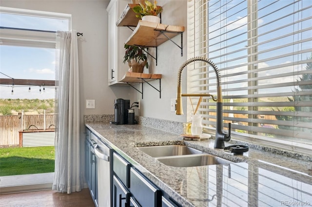 18079 E 108th Pl, Commerce City, CO 80022 - kitchen featuring a sink, open shelves, stainless steel dishwasher, white cabinets, and plenty of natural light