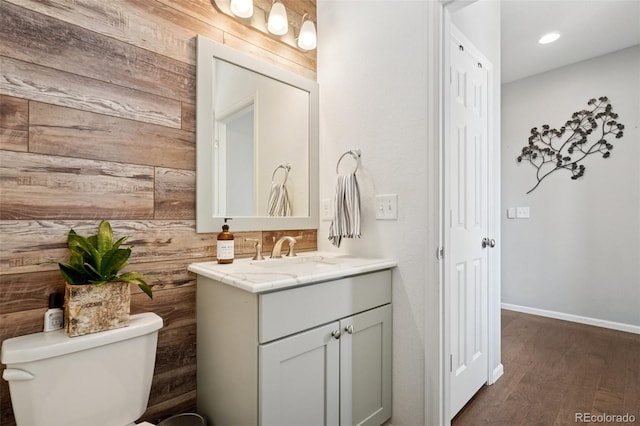 18079 E 108th Pl, Commerce City, CO 80022 - bathroom featuring wooden walls, vanity, toilet, wood finished floors, and baseboards