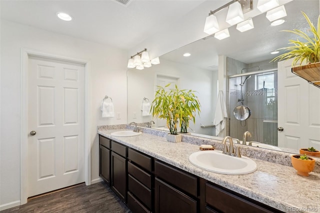 18079 E 108th Pl, Commerce City, CO 80022 - bathroom with double vanity, wood finished floors, and a shower stall