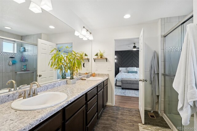 18079 E 108th Pl, Commerce City, CO 80022 - full bath featuring double vanity, a stall shower, wood finished floors, connected bathroom, and a ceiling fan