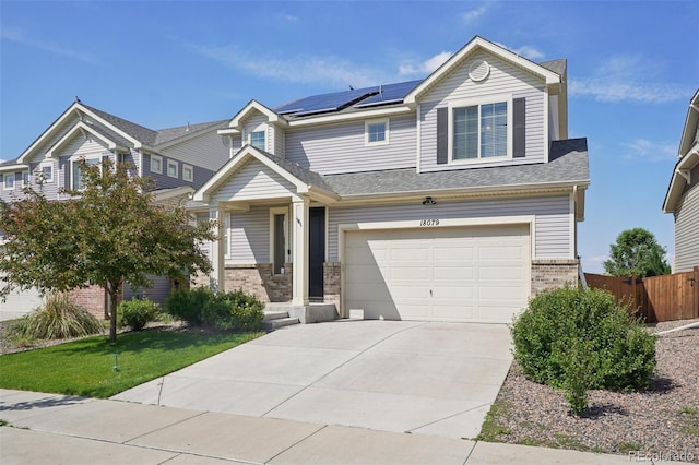 18079 E 108th Pl, Commerce City, CO 80022 - view of front of property featuring brick siding, a garage, solar panels, and concrete driveway