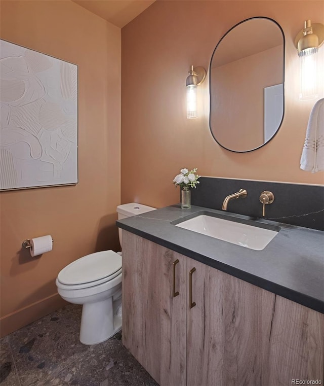 2450 S Cherokee St, Denver, CO 80223 - bathroom featuring vanity, toilet, and baseboards