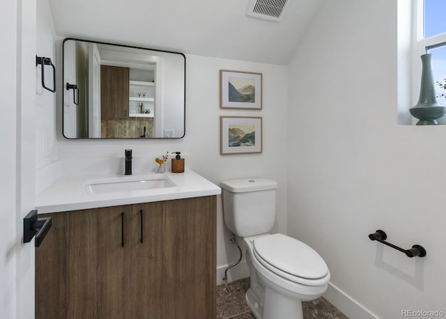 2450 S Cherokee St, Denver, CO 80223 - bathroom with toilet, vanity, baseboards, and vaulted ceiling