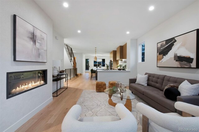 2450 S Cherokee St, Denver, CO 80223 - living room featuring light wood-type flooring, recessed lighting, baseboards, and a glass covered fireplace