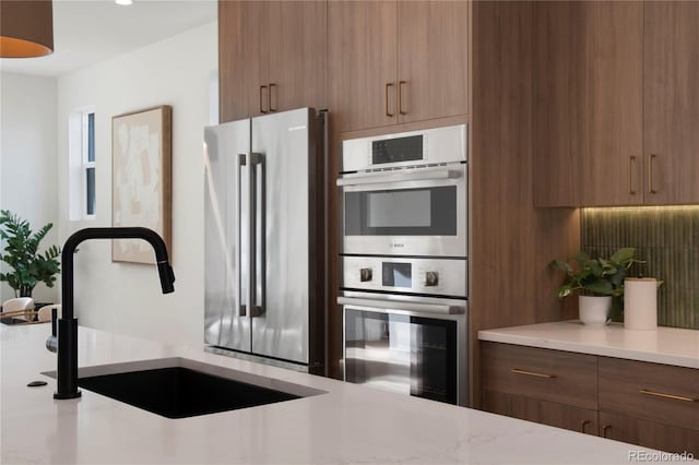 2450 S Cherokee St, Denver, CO 80223 - kitchen with stainless steel appliances, a sink, modern cabinets, and brown cabinets