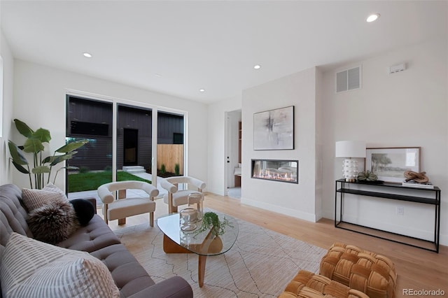 2450 S Cherokee St, Denver, CO 80223 - living room with a glass covered fireplace, light wood finished floors, recessed lighting, and baseboards