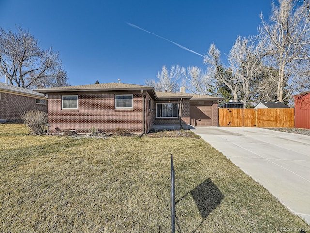 ranch-style house with a front yard, fence, an attached garage, concrete driveway, and brick siding