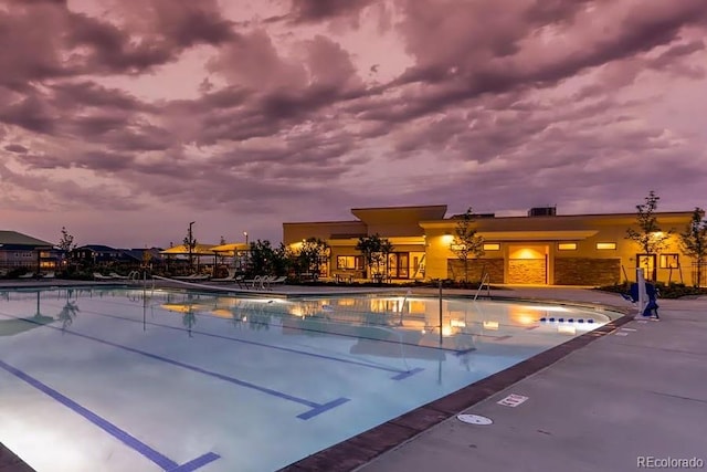 pool at dusk featuring a patio