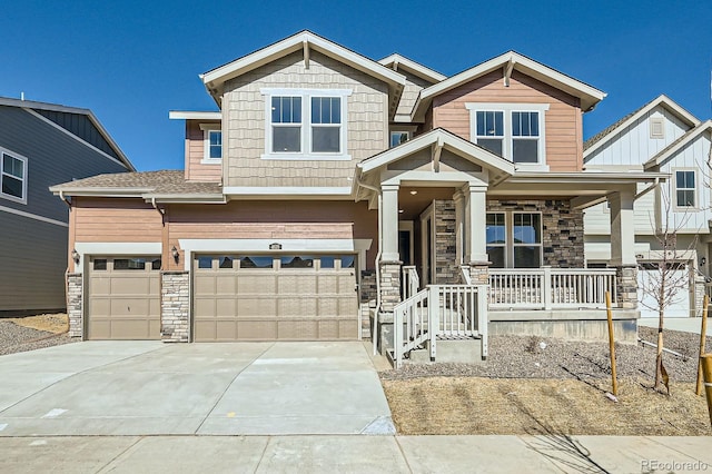 craftsman house featuring stone siding, a porch, and driveway