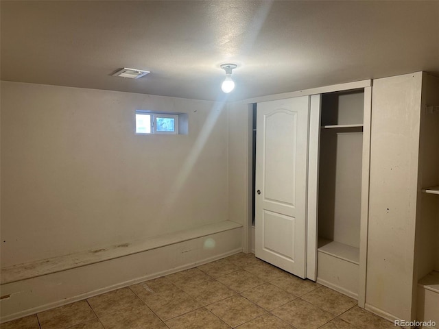 unfurnished bedroom featuring visible vents, a closet, and light tile patterned flooring