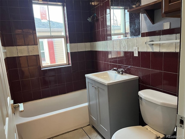 bathroom with toilet, vanity, tile patterned flooring, and tile walls