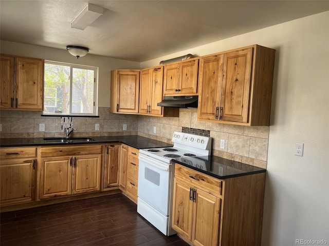 kitchen with a sink, dark wood-type flooring, under cabinet range hood, white range with electric stovetop, and dark countertops