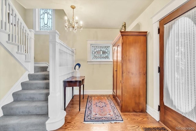 foyer with an inviting chandelier and light hardwood / wood-style flooring