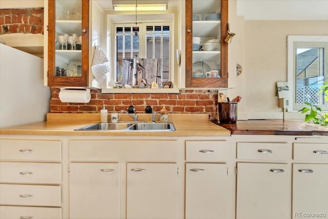 kitchen with tasteful backsplash, sink, and white cabinets