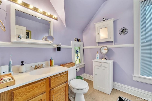 bathroom with lofted ceiling, vanity, tile patterned flooring, and toilet